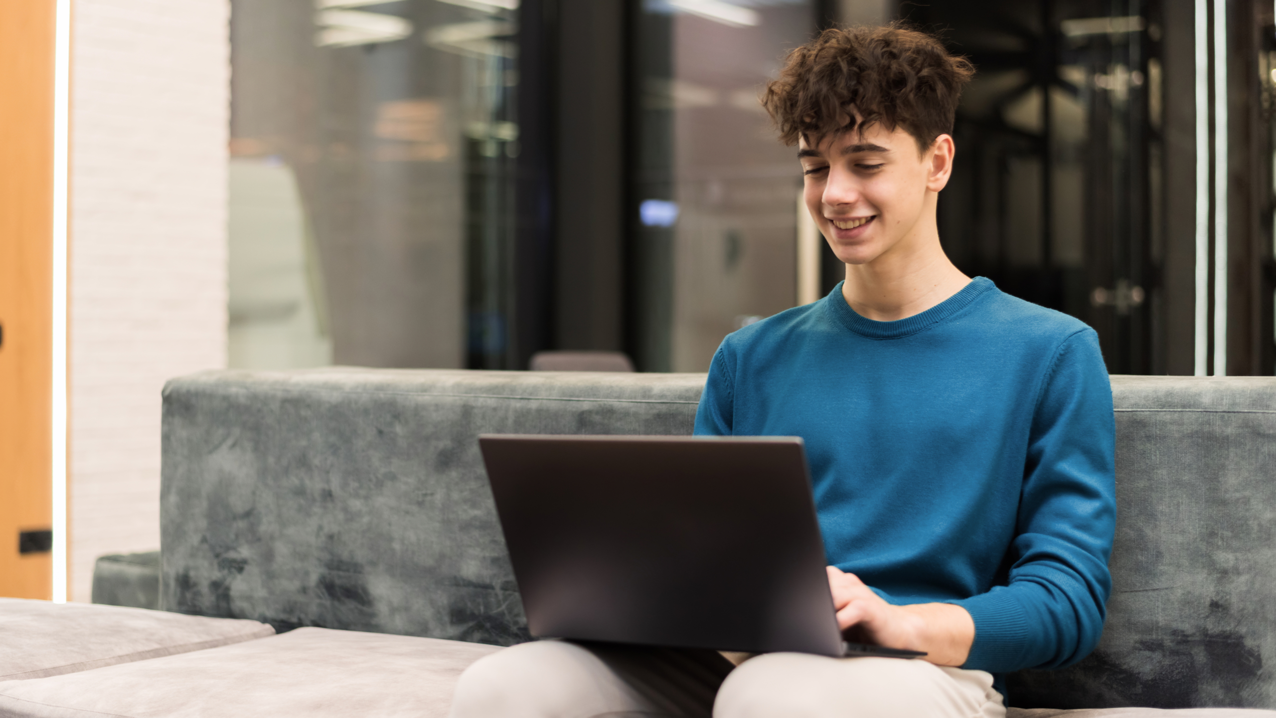 Young smiling man working with a laptop in an office