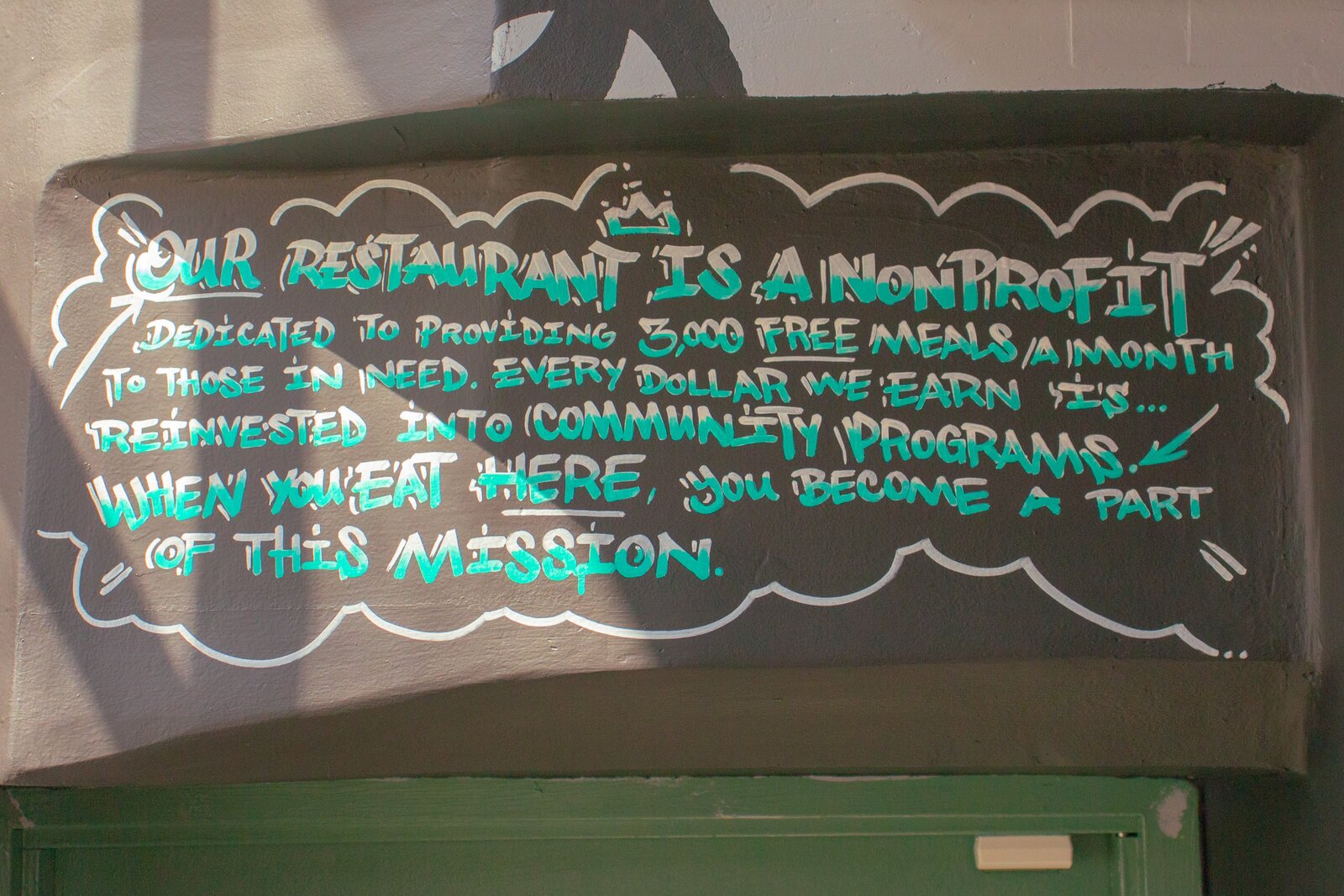 Hand-lettered board describing our non-profit mission